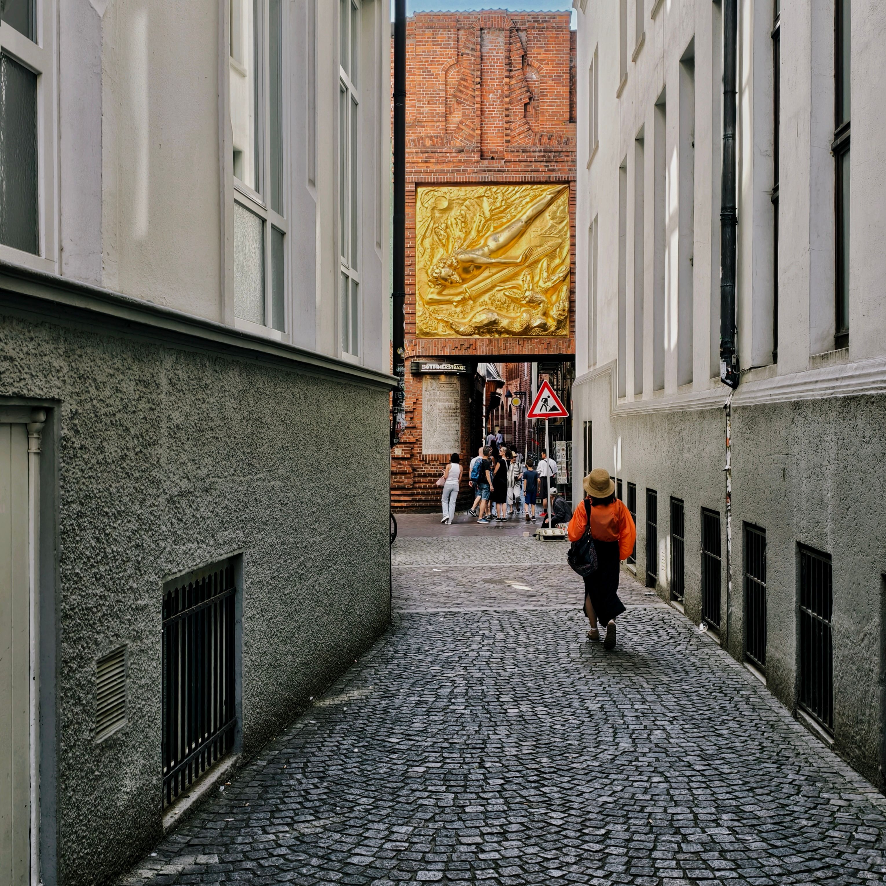 A woman walking through a cobblestone alley — photo by E. Space on Pexels