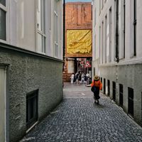 A woman walking through a cobblestone alley — photo by E. Space on Pexels