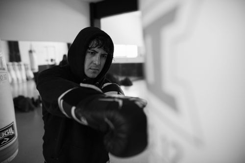 Free Focused boxer training with a punch bag in a Buenos Aires gym, showcasing dedication and skill. Stock Photo