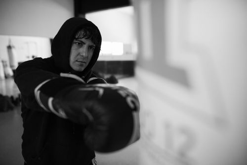 Free Black and white image of a boxer training intensely indoors, capturing a determined expression. Stock Photo