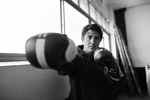 Free Black and white image of a male boxer throwing a punch in an indoor gym in Buenos Aires, Argentina. Stock Photo