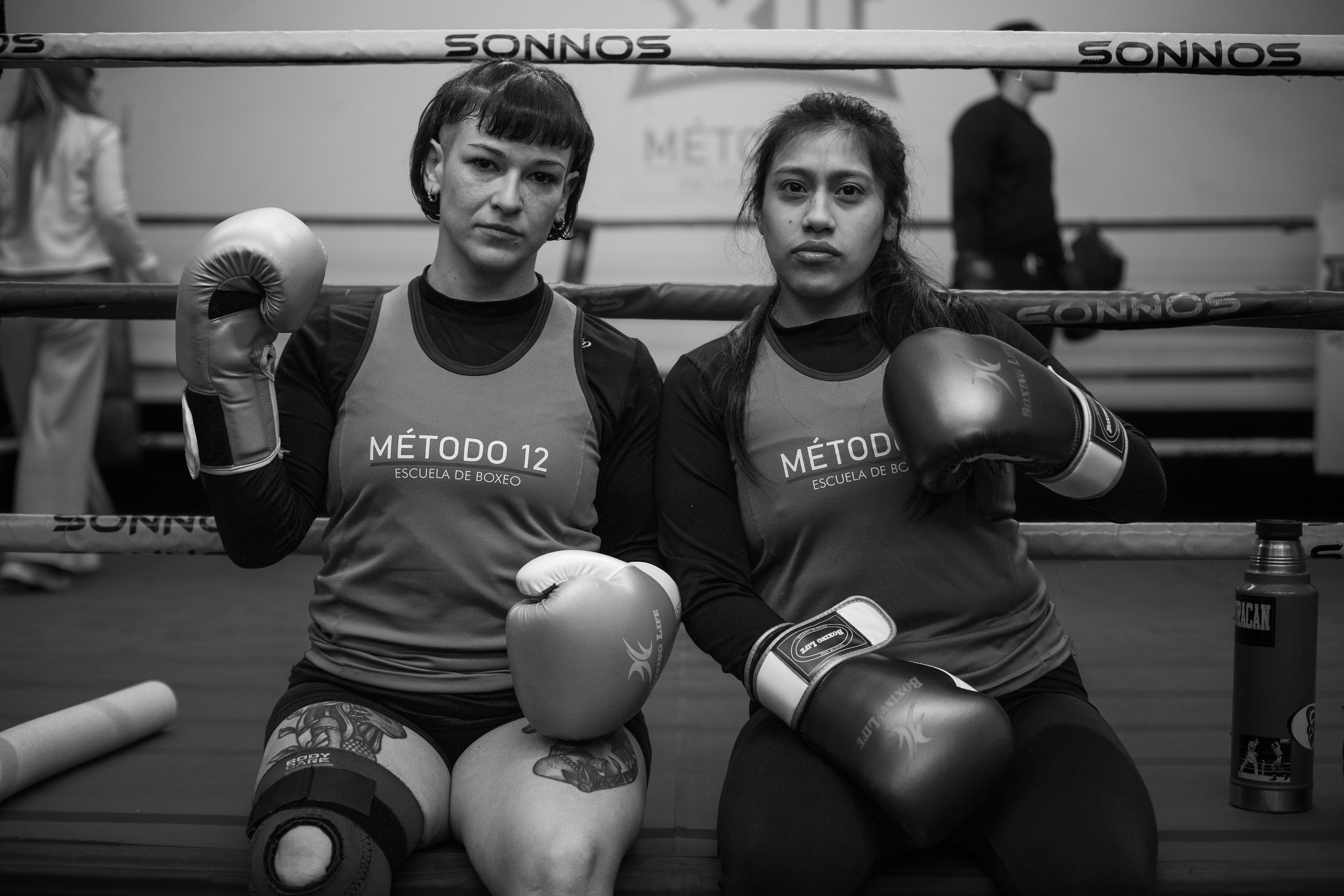 Two female boxers take a break in a Buenos Aires gym, showcasing intense focus and dedication.