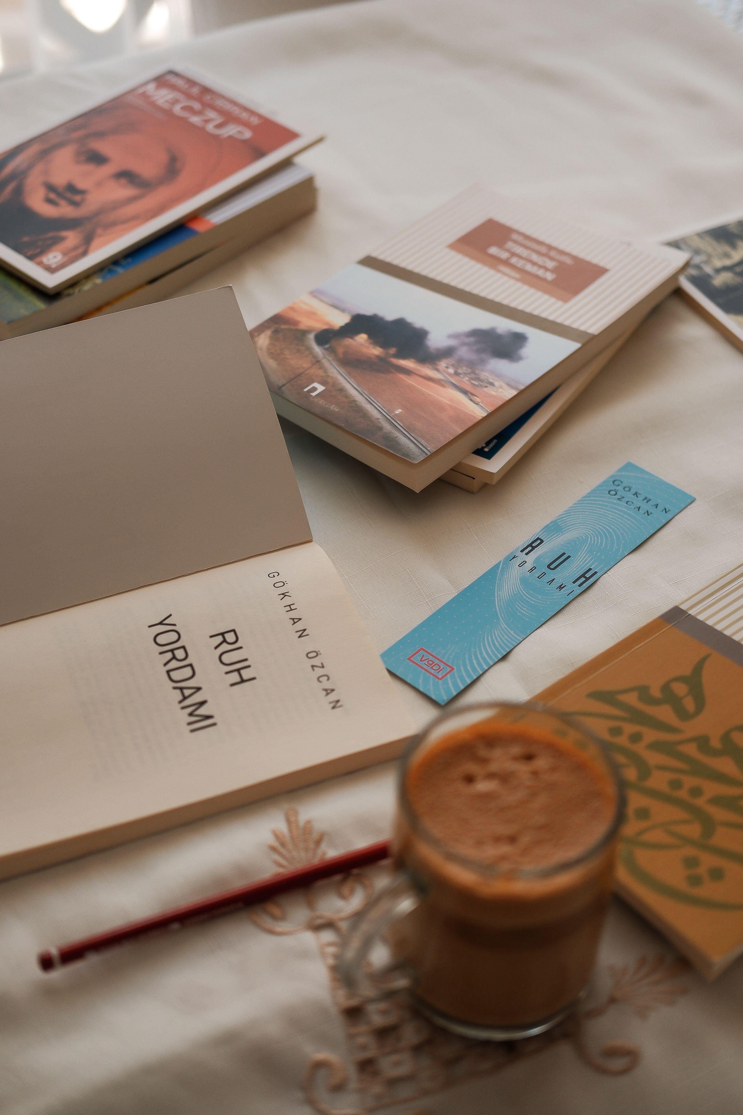 Top view of books on a table with coffee and bookmark, creating a cozy reading atmosphere.