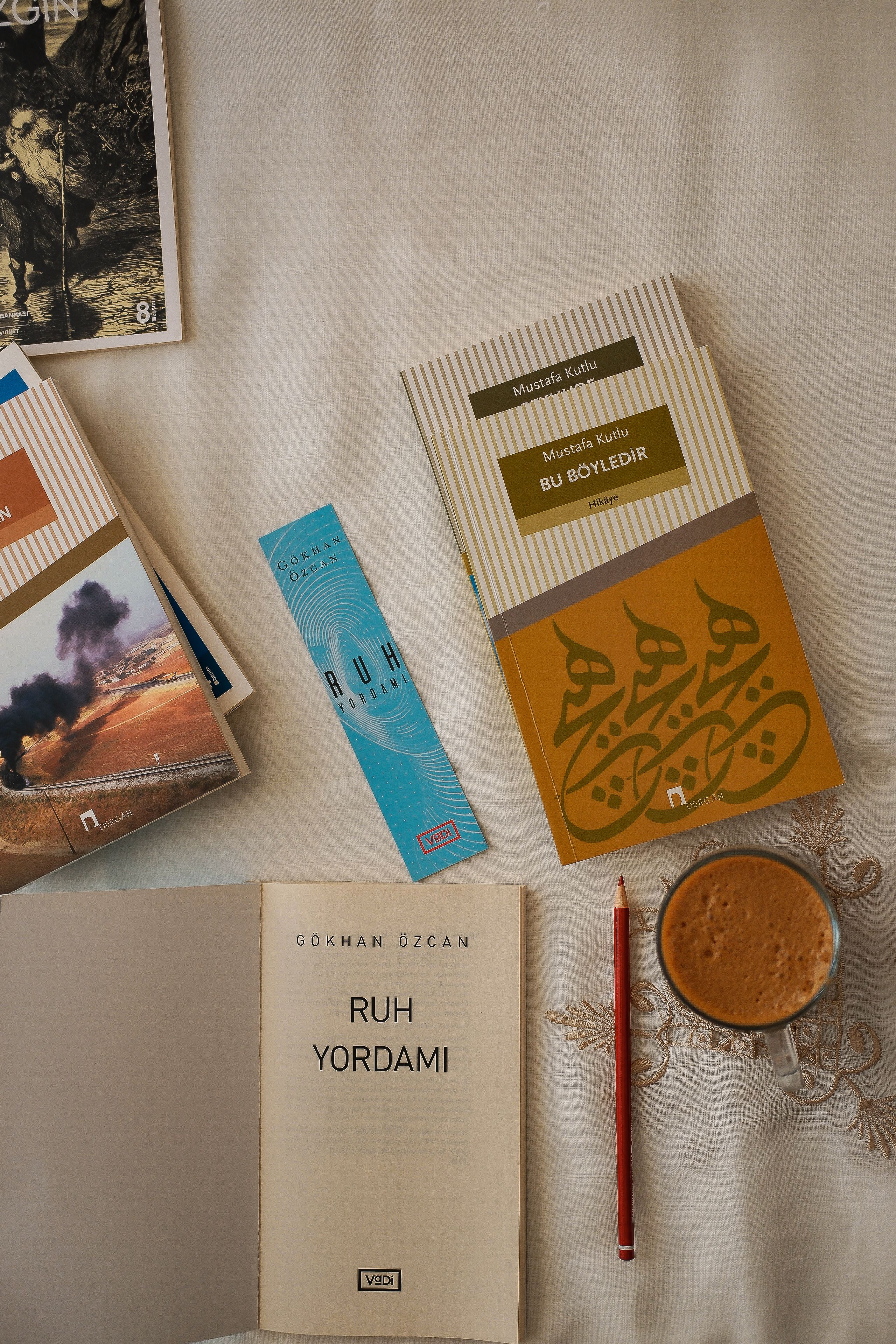 Flat lay of books, coffee, and pencil on a cozy reading space.