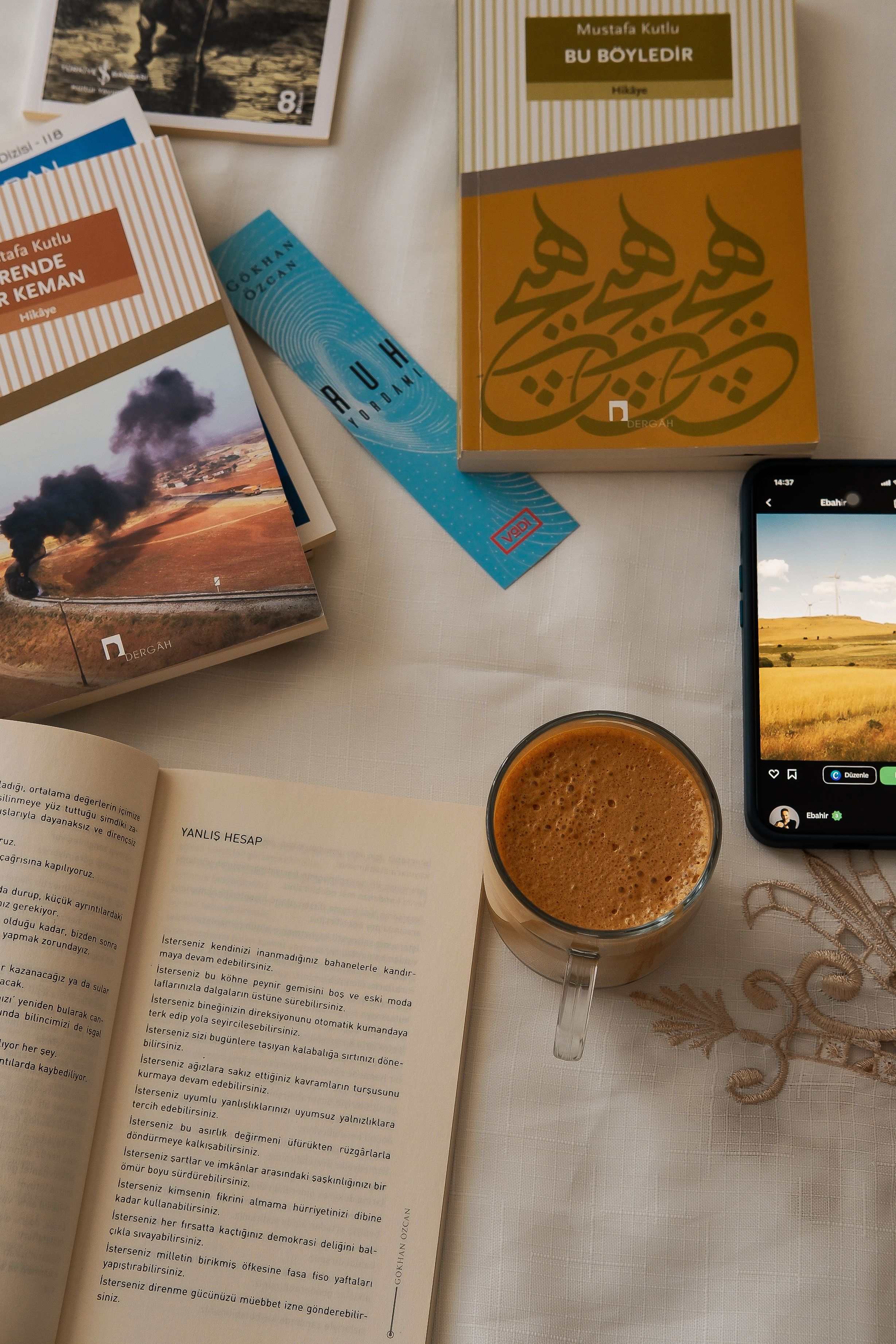 A warm and inviting reading scene featuring books, coffee, and a smartphone, ideal for a relaxing day indoors.