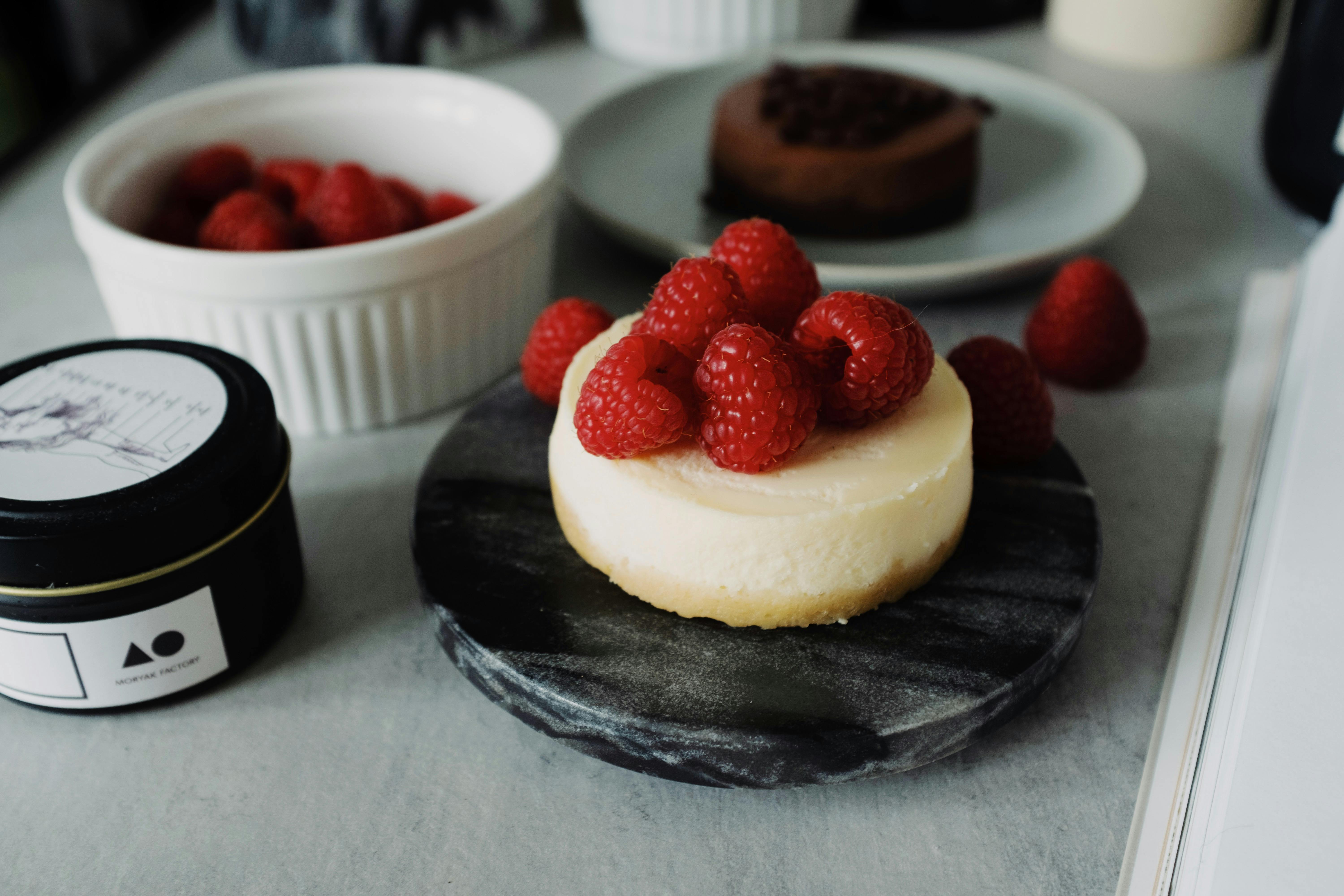 A delicious raspberry cheesecake on a marble board, ideal for food photography enthusiasts.