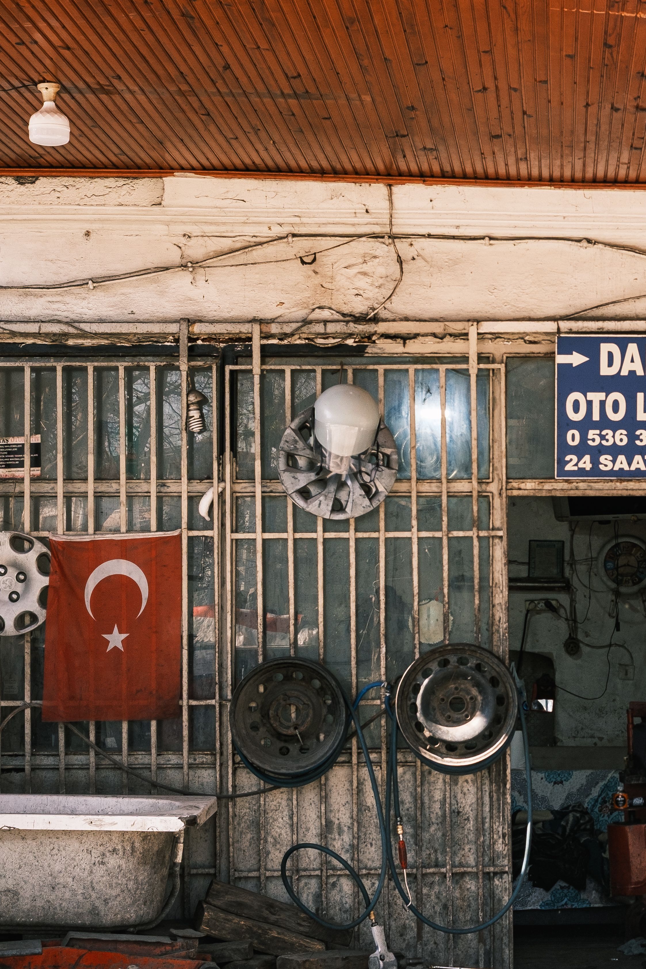 Exterior of a Turkish auto repair shop featuring a Turkish flag and various auto parts.