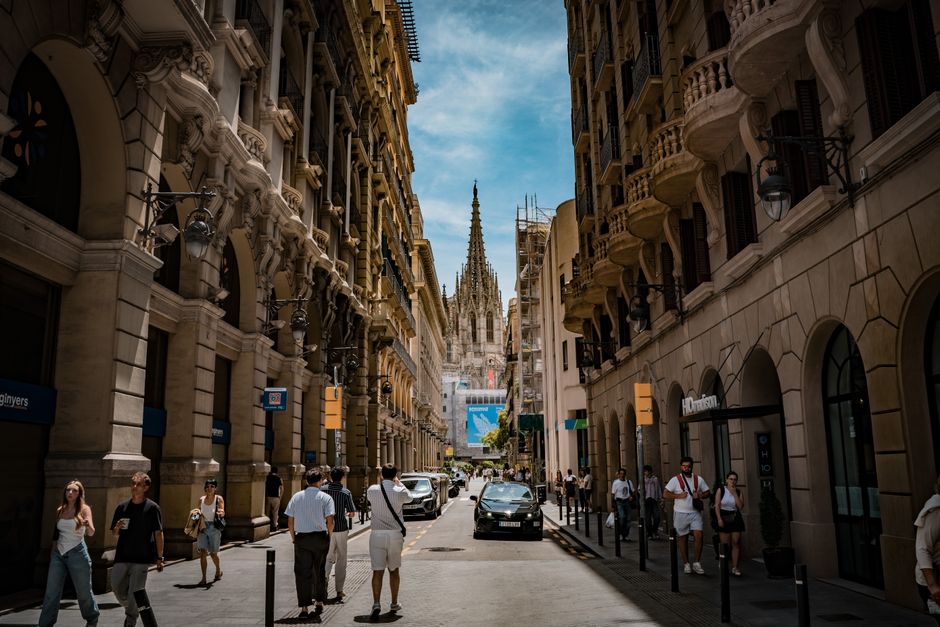 Encantadora vista de calle en el Barrio Gótico de Barcelona con arquitectura icónica y la catedral al fondo.
