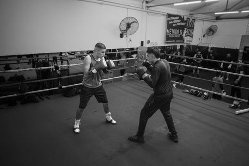 Free Two boxers practicing in an Argentine gym, surrounded by equipment and onlookers. Stock Photo