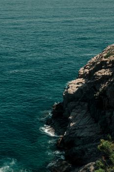 Majestic rocky cliffs overlooking the blue sea in Tossa de Mar, Cataluña.