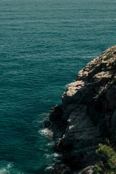 Rugged rocky coastline meeting the Mediterranean Sea in Tossa de Mar, Spain.