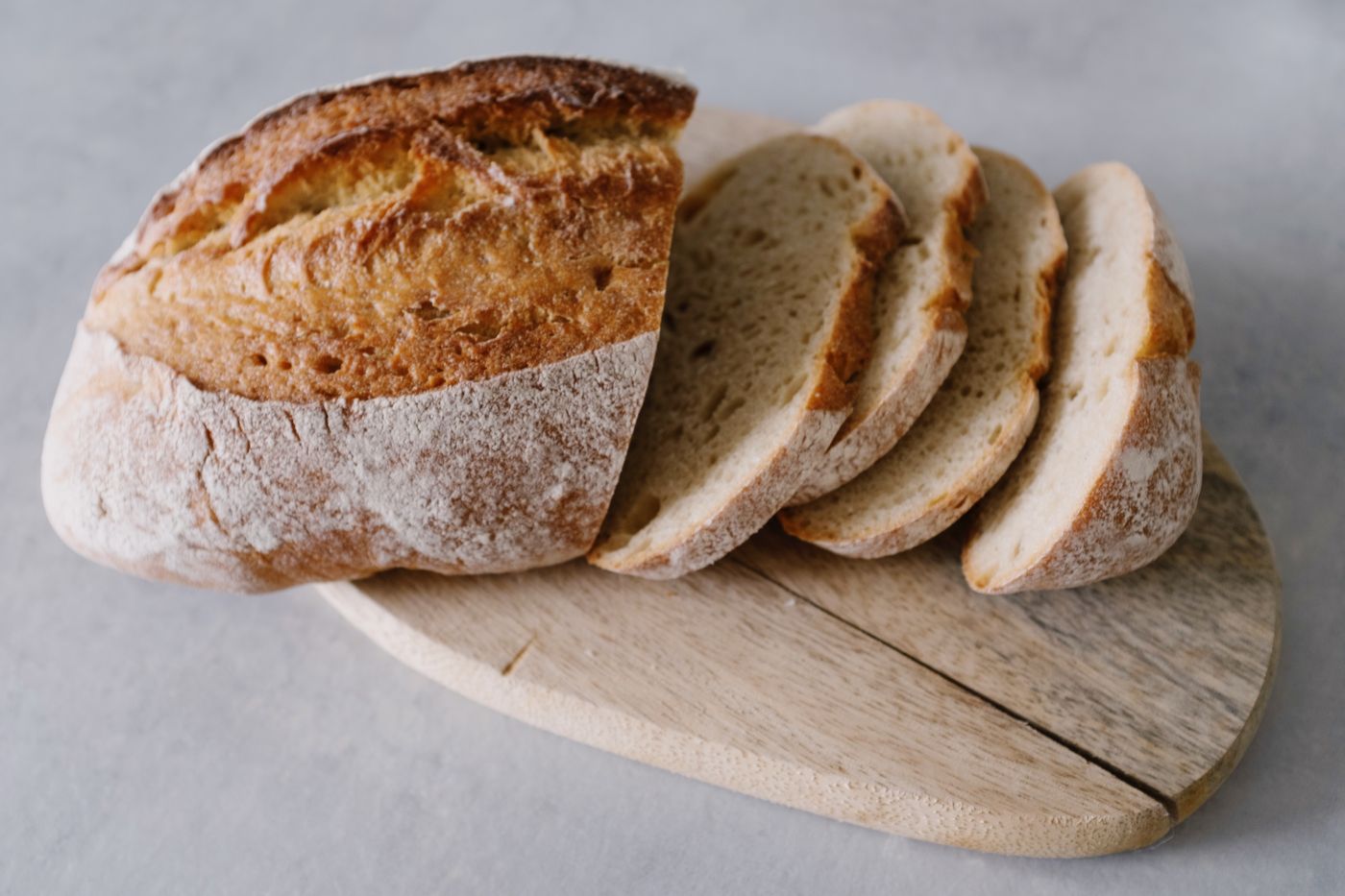 Rustic sliced loaf of bread on a wooden chopping board