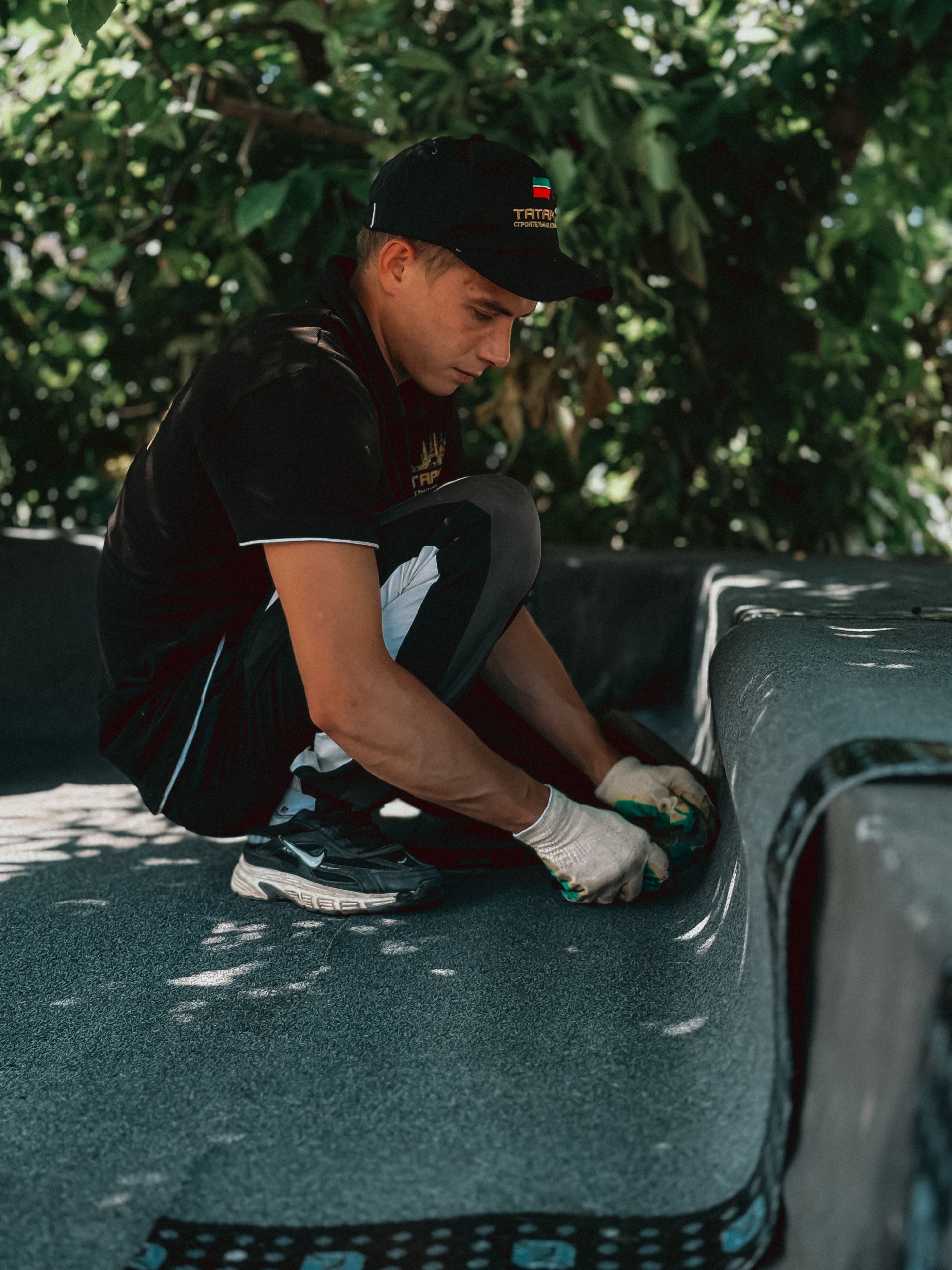A skilled worker installing roofing material outdoors, showcasing construction expertise and precision.