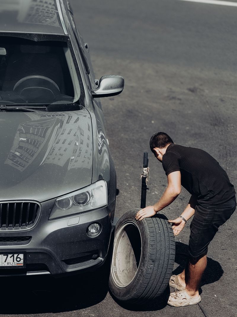 Fitter changing a car tyre at the roadside