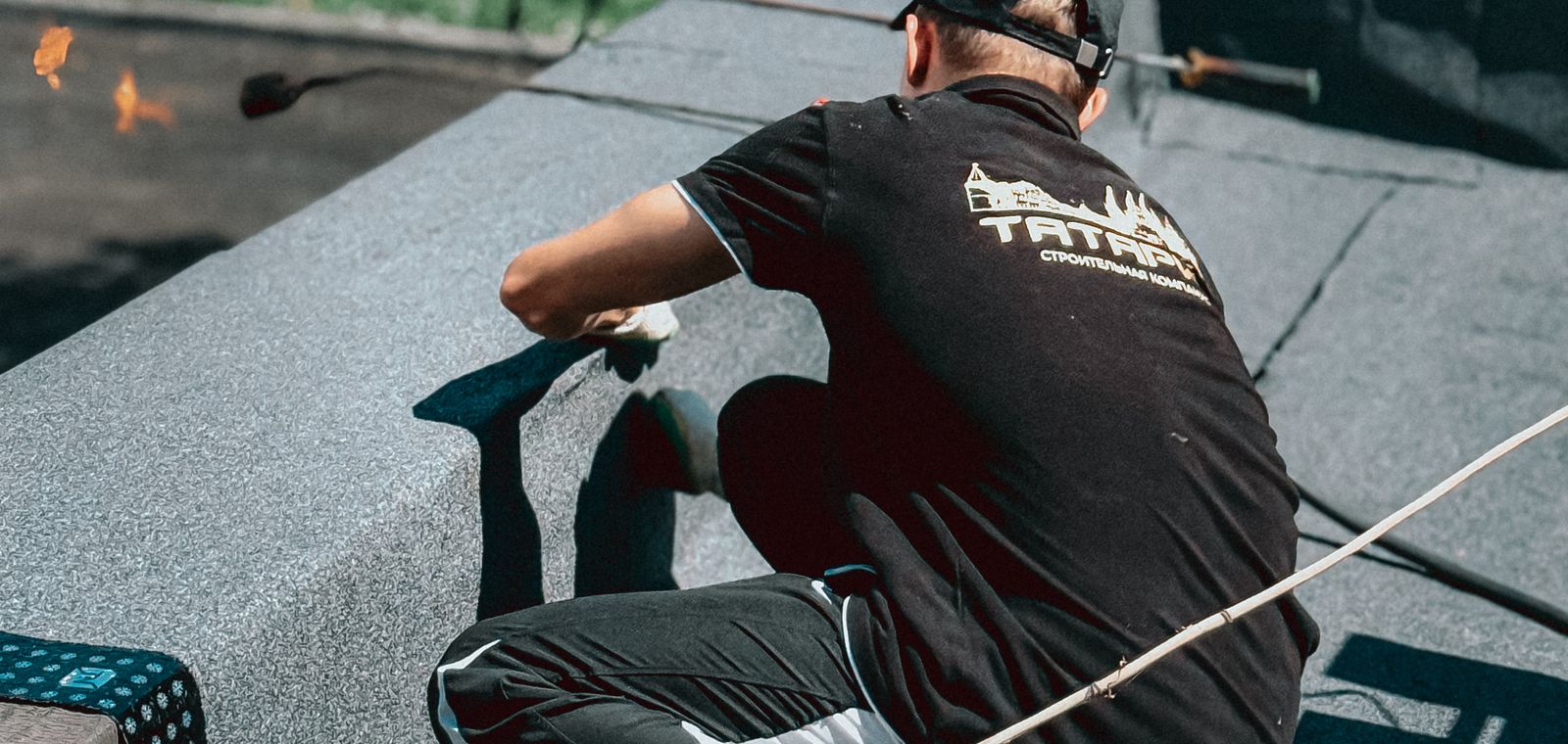 Roofer working on a flat roof in the sun