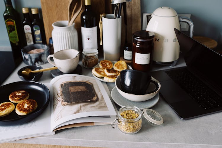 Countertop With Various Kitchenware Cheese Pancakes And Laptop