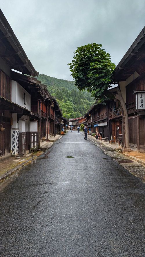 Free A serene, rainy day view of a traditional wooden street in Saku, Nagano, Japan, showcasing historic architecture. Stock Photo