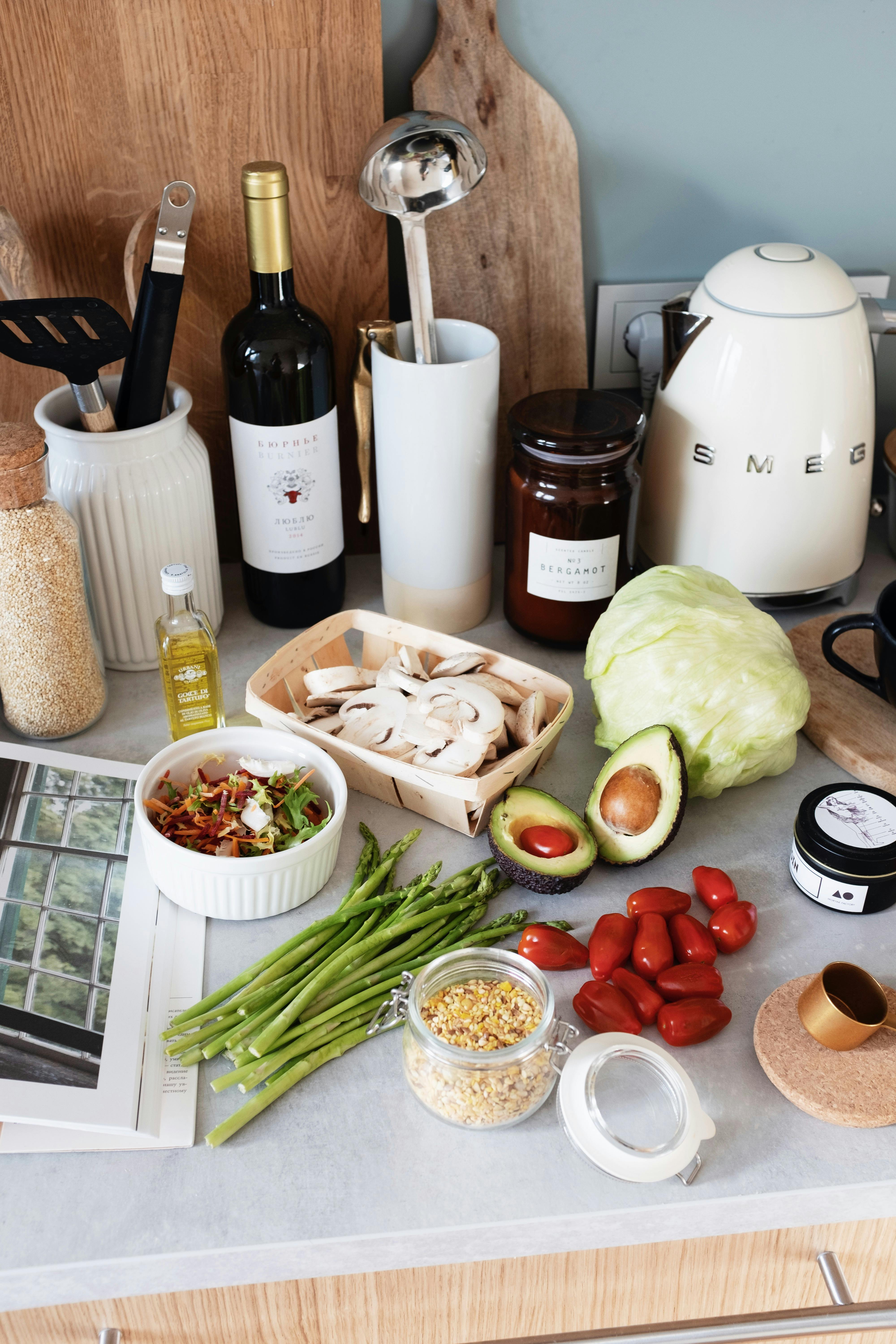 A vibrant display of fresh vegetables and kitchen essentials arranged on a countertop.