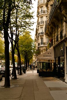 A picturesque Paris street featuring elegant architecture and autumnal trees.