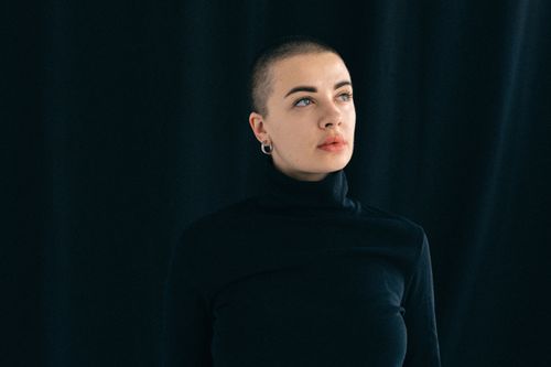 Free Stylish portrait of a woman in black, looking thoughtfully upward. Stock Photo