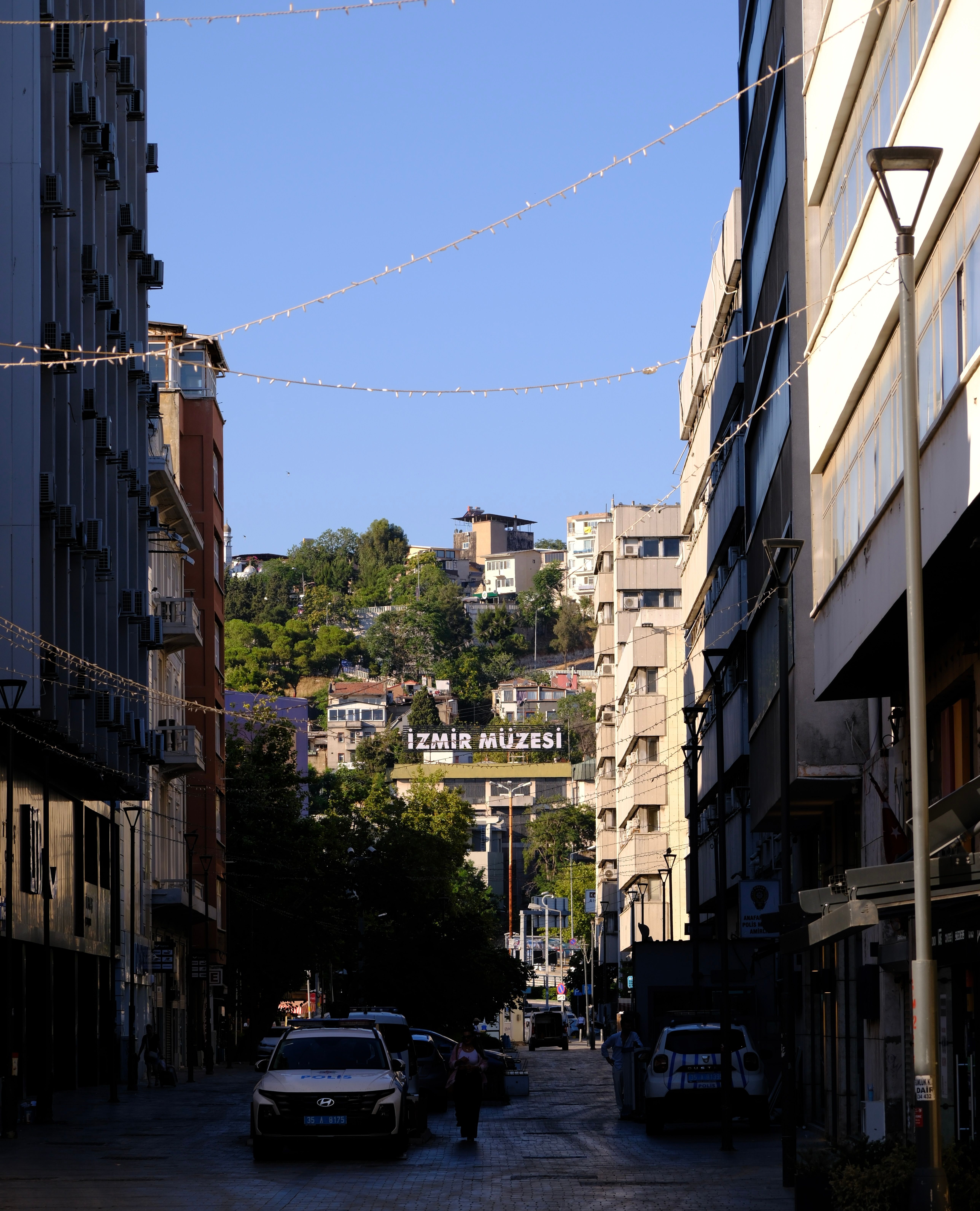 Street view towards İzmir Müzesi with urban landscape and clear sky.