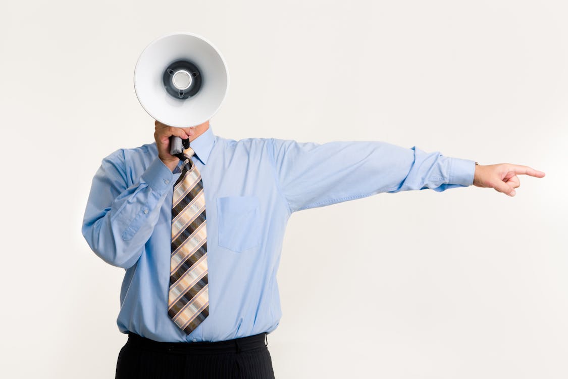 Free Man With Megaphone Pointing Stock Photo - (Image Source: WallStreetMojo)