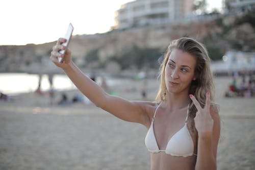 Free Woman In White Bikini Top Holding Smartphone Stock Photo