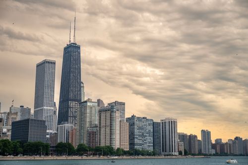 Free Dramatic view of Chicago skyline featuring the iconic John Hancock Center at sunset over Lake Michigan. Stock Photo