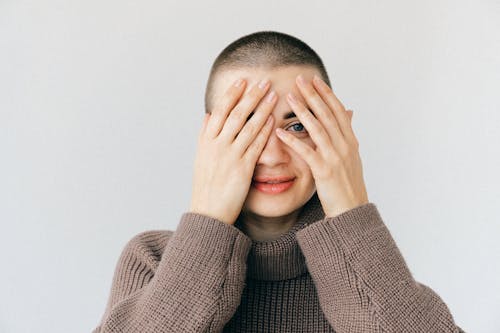 Free Woman in Brown Turtleneck Sweater Covering Her Face Stock Photo