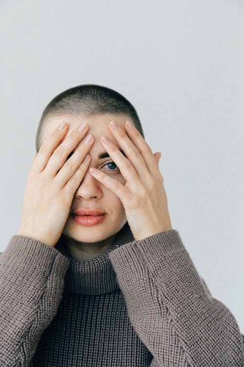 Woman with Short Hair Wearing Gray Knit Sweater Covering Her Face