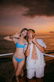 Young couple enjoying a lively moment by the beach at sunset in Puerto Vallarta, Mexico.