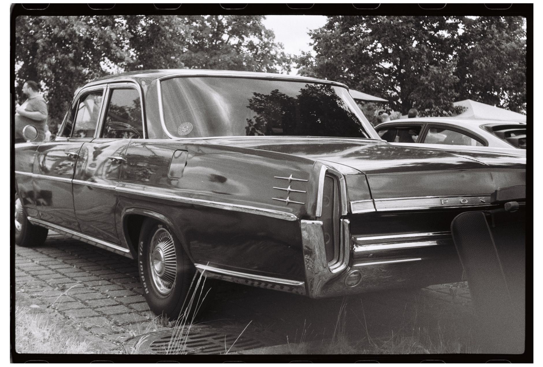Black and white photo of a classic vintage car at an outdoor auto show. — free online jigsaw puzzle on JigsawPuzzlesFreeOnline.org