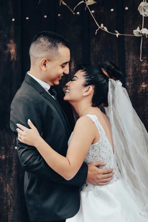 Free A joyful bride and groom embrace with smiles on their wedding day, filled with love and happiness. Stock Photo