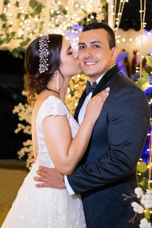 Free Bride kisses groom in a romantic wedding setting with elegant decor. Stock Photo