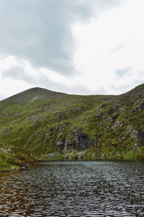 Free Scenic view of tranquil lake surrounded by lush green hills in Ireland. Stock Photo