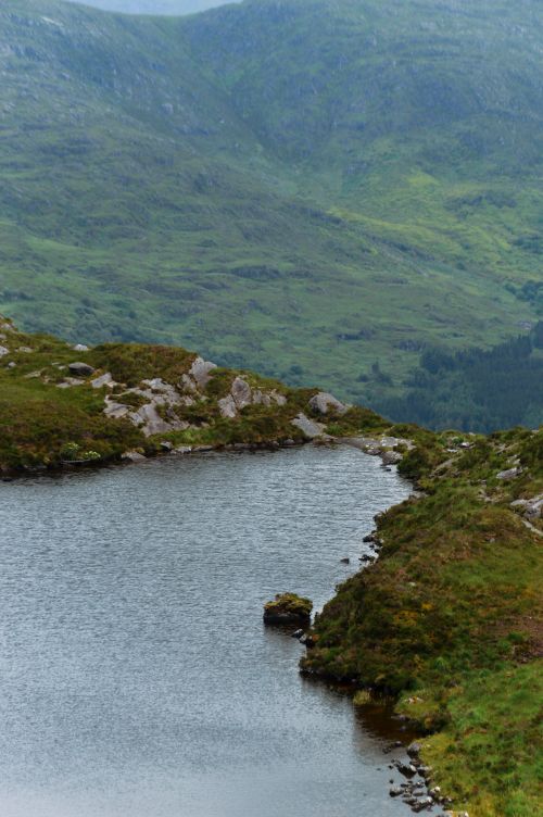 Free Tranquil lake surrounded by lush green Irish highlands, ideal for nature lovers. Stock Photo