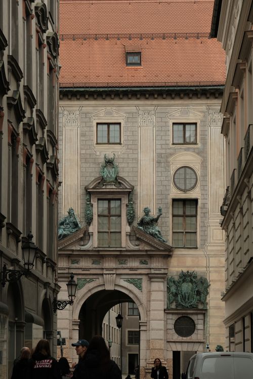 Free A view of historic architecture in Munich, featuring ornate facade details and a red-tiled roof. Stock Photo