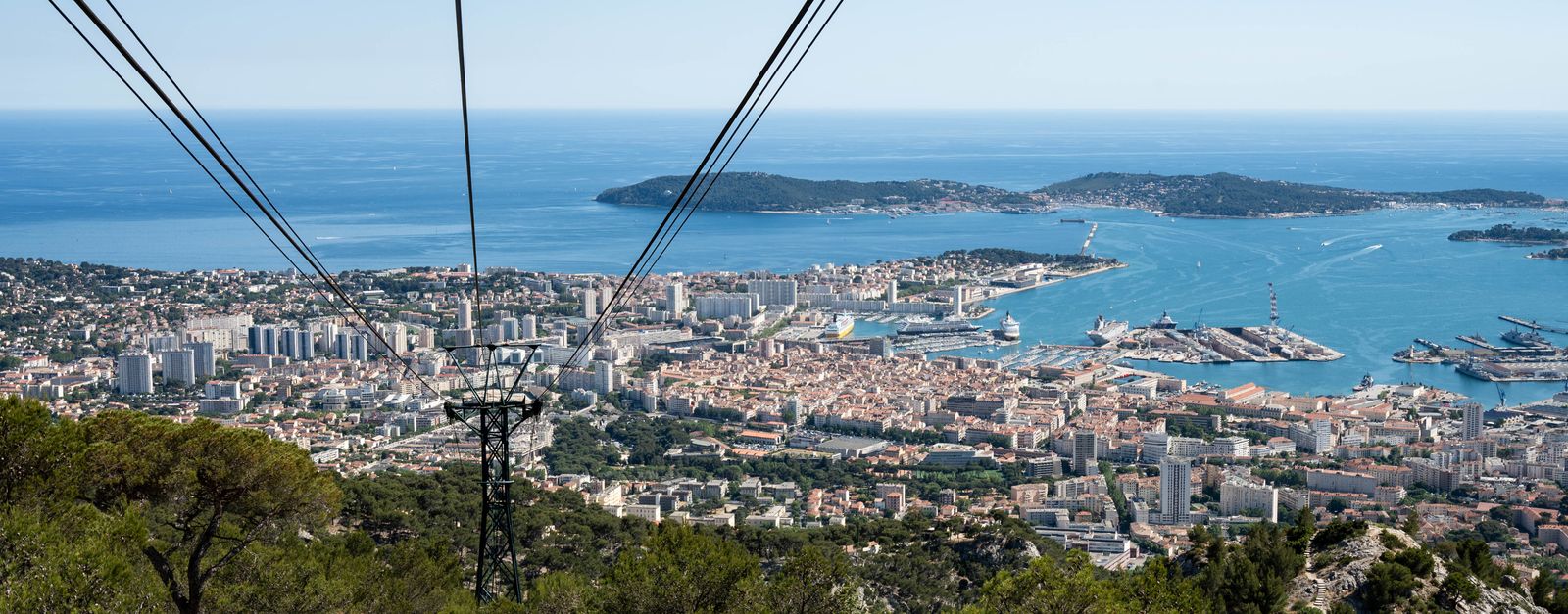 A stunning aerial view of Toulon city and the Mediterranean Sea from a hillside cable car perspective.