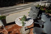 Outdoor cafe with a menu board and table setting in sunny Provence, France.