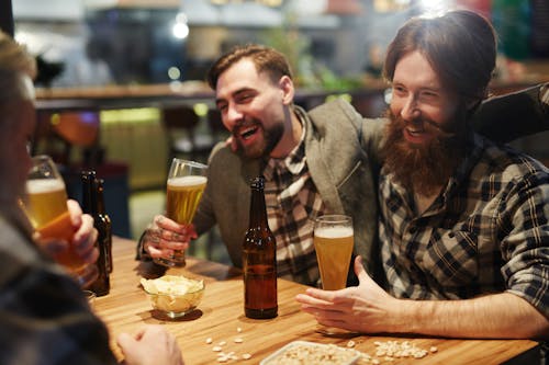 Free Men Laughing and Drinking Beer Stock Photo