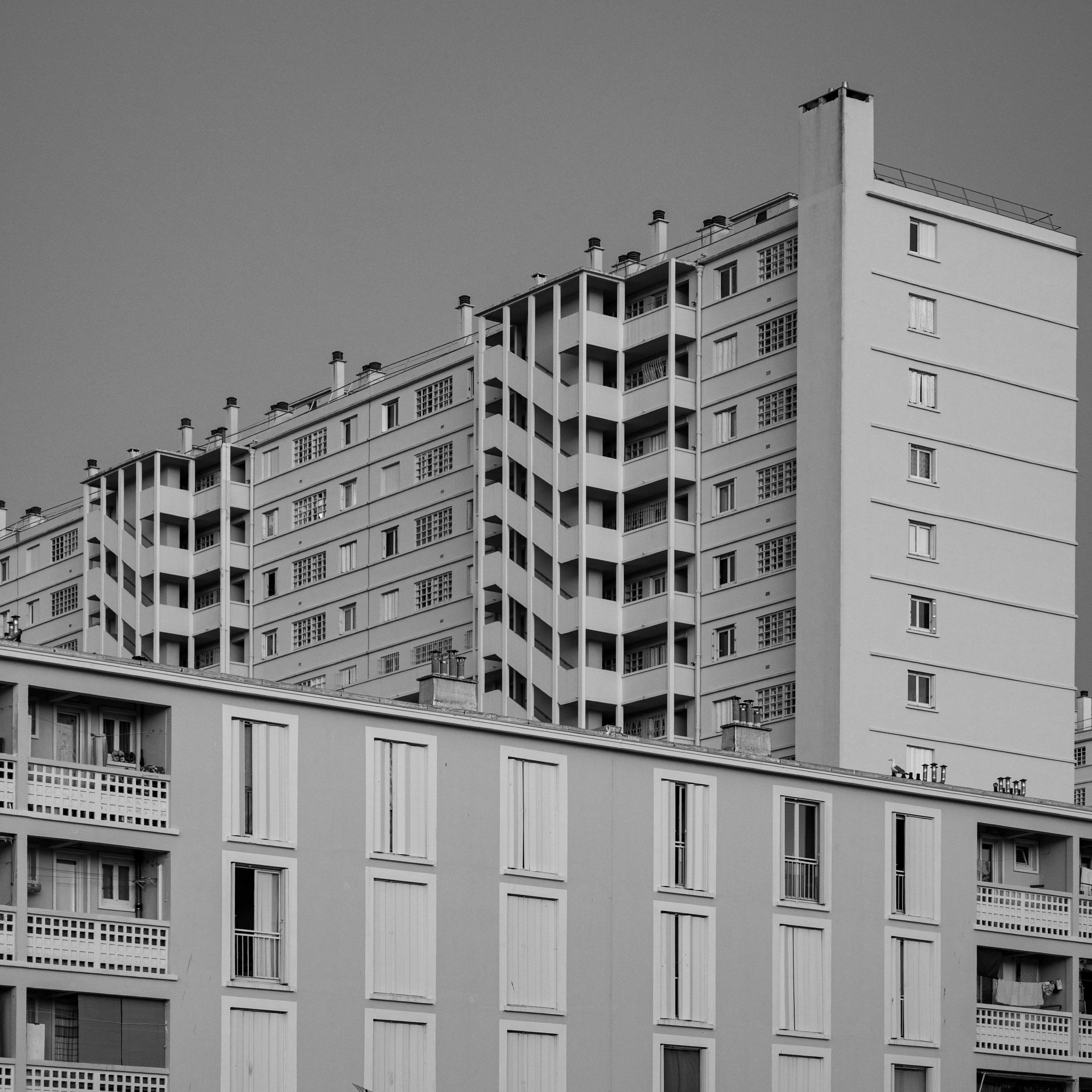 Monochrome photograph of urban apartment buildings in Toulon, France, showcasing modern architecture.