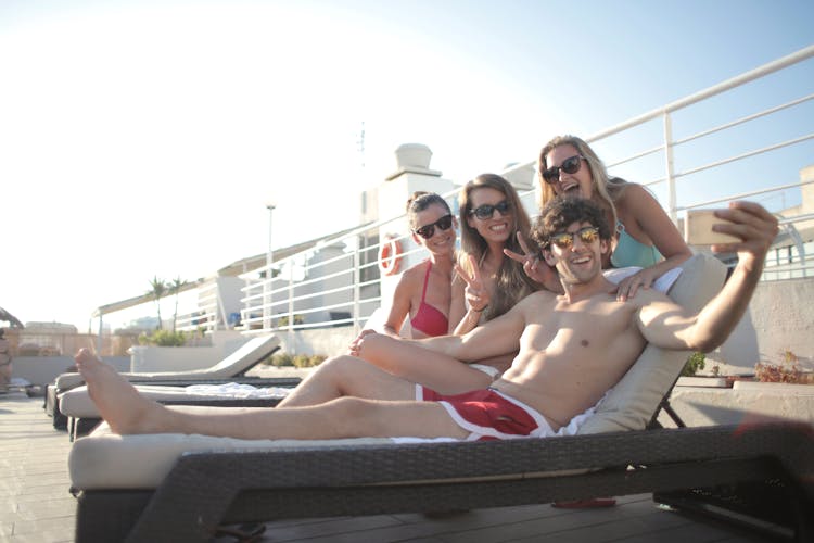 Happy Young People Spending Vacation Together And Taking Selfie