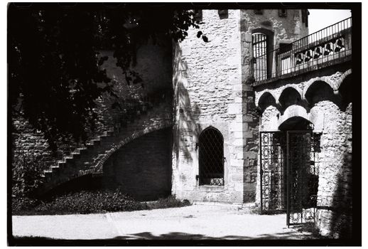 Black and white photo of classic stone architecture with iron gate.