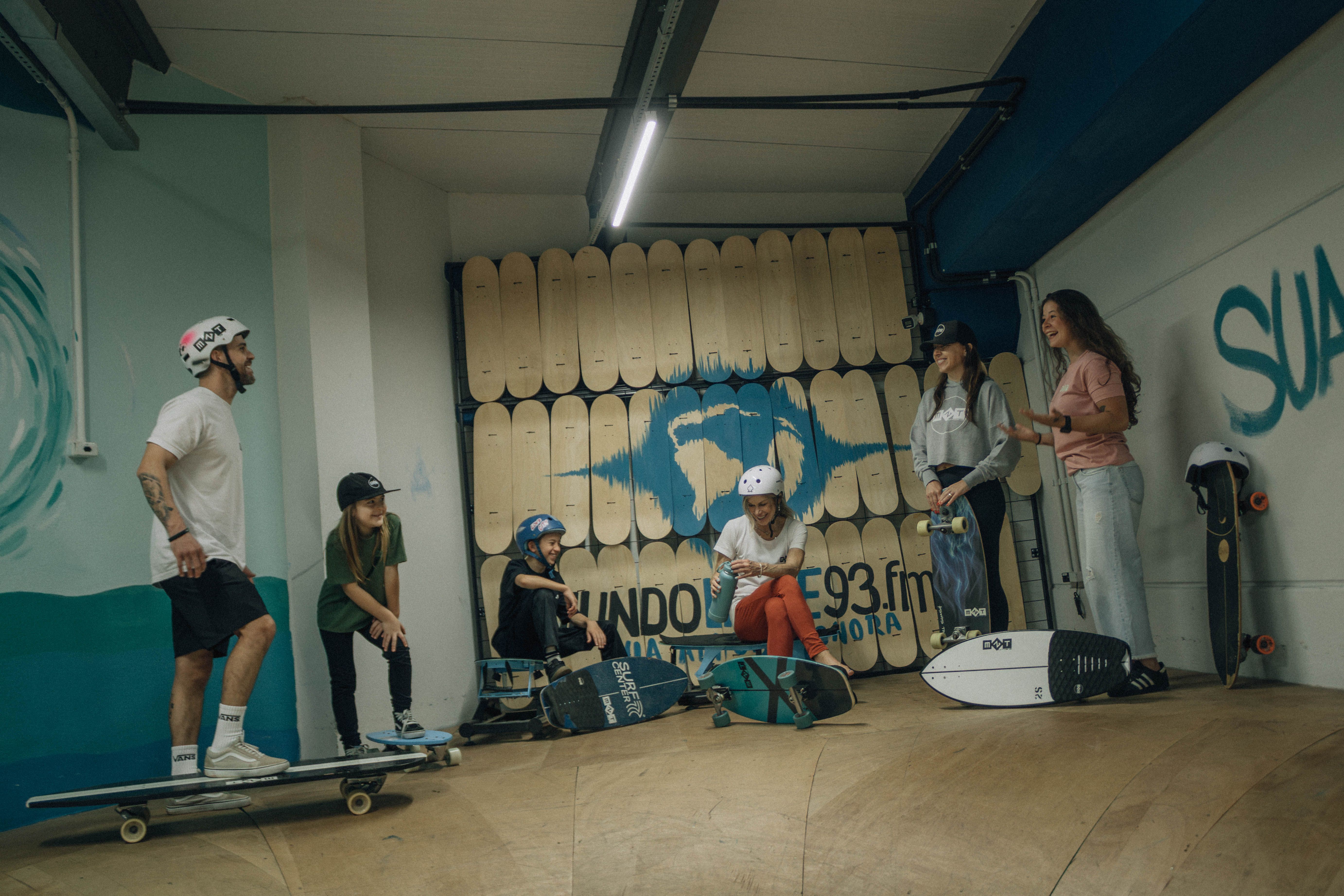 Group of young people skateboarding indoors, enjoying a fun and lively activity in a skate park.