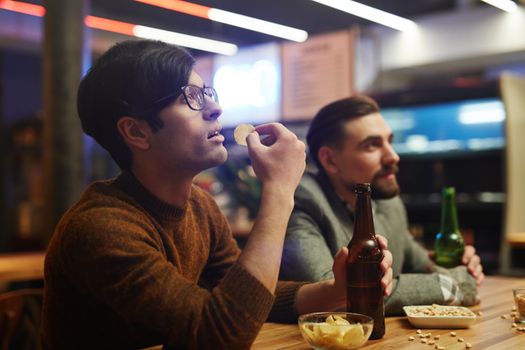 Man in Brown Eating Chips