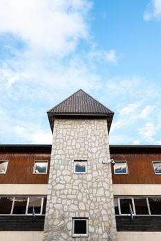 A historic stone tower in Ushuaia, Argentina, stands tall against a vibrant blue sky.