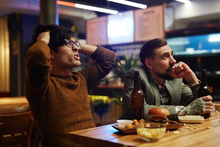 Man Holding His Head At A Bar