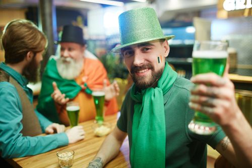 Free Group of men celebrating with green beer and costumes for St. Patrick's Day. Stock Photo