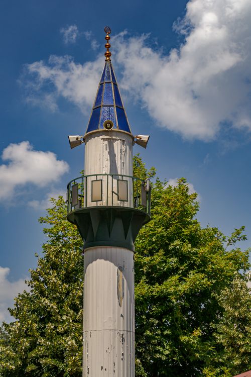 Free Tall, ornate minaret in Bursa, Türkiye, with lush greenery and blue sky backdrop. Stock Photo
