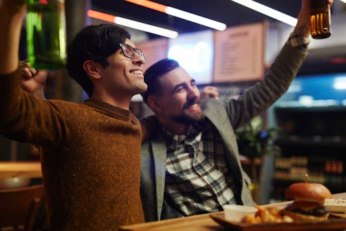 Free Men Celebrating at a Bar Stock Photo